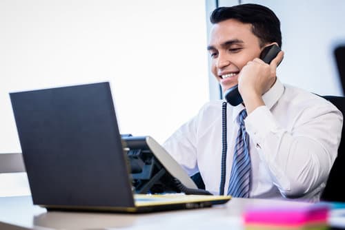 Picture of young man smiling while on the phone.